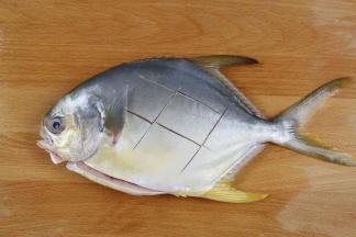 
把鱼清洗干净内肚，表皮上浅浅的划几刀，沥干表面水分。