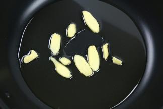 不粘锅里放入食用油，加入姜片，小火加热。