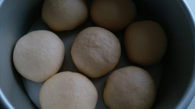 像包包子一样，捏紧收口，收口朝下放入模具内，放入烤箱进行二发，烤箱内放碗热水增加湿气