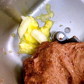 除黄油和巧克力豆之外的食材全部放进面包桶中，启动和面程序揉成光滑的面团后加入软化的黄油揉至扩展阶段