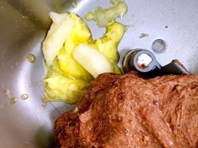 除黄油和巧克力豆之外的食材全部放进面包桶中，启动和面程序揉成光滑的面团后加入软化的黄油揉至扩展阶段