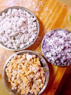 制作方法：蒸熟的果泥加入木薯淀粉，建议大家木薯粉不要一次性加足。可以先倒入一部分，先用筷子搅拌，待面团稍硬后再用手揉，揉搓成干的，有弹性的面团就算是成功了。芋头和紫薯会干一点，可以适量加一点水。芋头泥里面我还加入了少许黑芝麻。切丁的时候可以在案板和盘子上撒上少许面粉，防止芋圆粘连。