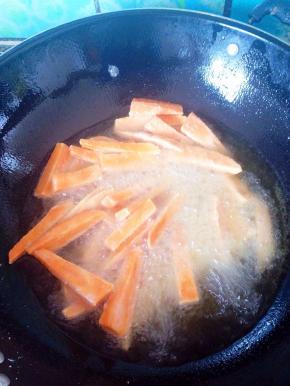 锅中油烧热后放入地瓜条油炸。注意控制好火候。温度大约在160度左右炸5分钟出锅，出锅前转大火。这样是为了逼油。