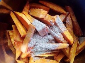 趁热倒入甘梅粉，上下左右晃动盆子，让每一条地瓜条都均匀的裹上甘梅粉。