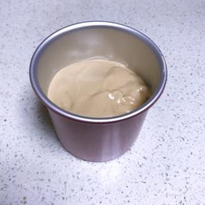 将面糊从高处倒入模具中，轻震出气泡。