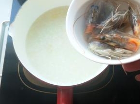 将清洗干净的虾头放入米粥熬煮