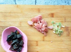准备好鸡蛋皮蛋粥的材料。瘦肉切片，皮蛋切小块，葱段切碎