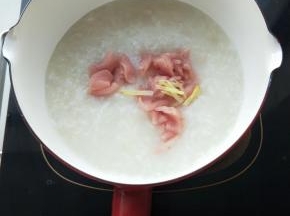 粥煮开加入瘦肉小火熬煮。
加入姜丝，个人认为加点姜丝去大肉的腥味