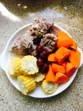 猪骨头冼净放锅里焯一下水，捞出用水冲去浮沫，玉米洗净切段，胡萝卜切块，红枣洗净