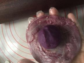 26. 用擀面杖把皮子擀大，包入之前准备好的紫薯蛋黄馅