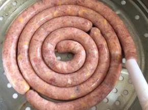 轻轻的旋动灌肠神器的手柄，肉馅就很轻松的灌进肠衣里面了！不要灌的太满，7分满即可！太满蒸的时候会涨破的哦  整齐的码放在蒸笼里面。
