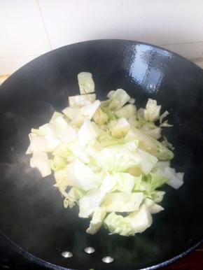 铁锅烧热加入植物油，油温升起放入洗净的包菜。