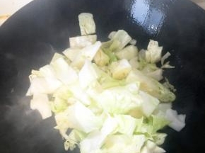 铁锅烧热加入植物油，油温升起放入洗净的包菜。