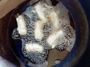 里脊肉粘上面糊后放入油中炸。油温5成热。