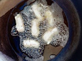 里脊肉粘上面糊后放入油中炸。油温5成热。