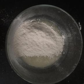 在油水混合物中筛入低筋面粉，用手动打蛋器无规则的搅拌成均匀细腻的面糊。