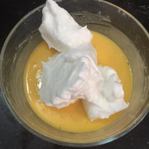 取三分之一蛋白放入蛋黄液中，用翻拌与切拌手法将两者混合均匀。