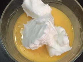 取三分之一蛋白放入蛋黄液中，用翻拌与切拌手法将两者混合均匀。