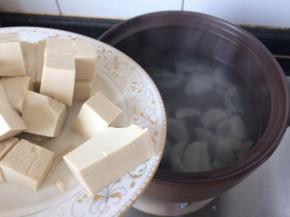 砂锅里倒入豆腐，花卷也上锅，蒸十五分钟左右。