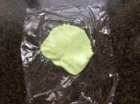 取一块保鲜膜，将一小团面放上，压薄。