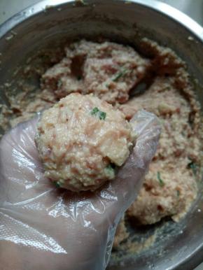 肉泥抓在手心，从虎口处挤出肉圆