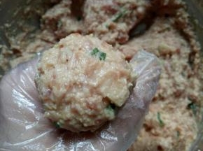 肉泥抓在手心，从虎口处挤出肉圆
