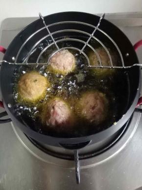 放入油锅，中小火慢炸，等肉圆凝固后，用筷子翻动肉圆，防止焦糊