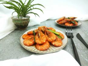 拿一个虾，虾壳外面的酱汁也好吃，虾肉紧实，味美。