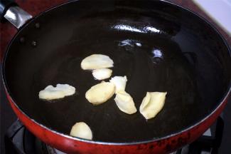 烧红锅后，加入少许花生油，然后加入姜片，爆出姜味。