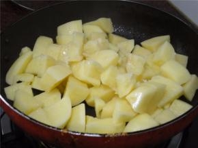 锅里下油，加入土豆块，翻炒。