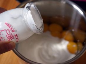 蛋黄中加入250克自制酸奶，充分搅拌均匀。