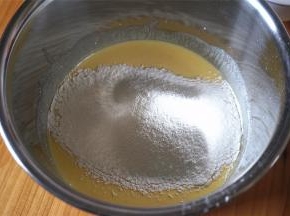往搅拌好的蛋黄液中筛入低粉和粟粉（玉米淀粉）。