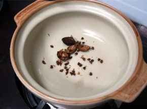 将草果放到砂锅里，并开火烧热砂锅。