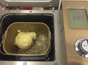 1.	将除黄油以为的所有液体材料放入面包机桶内，启动和面程序，揉成光滑能拉出有弹性的薄膜后放入黄油，总时间为20分钟
