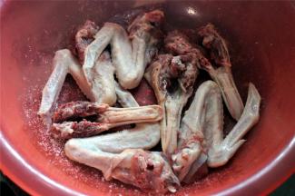 用一个大容器腌制鸭头。先铺一层鸭头。