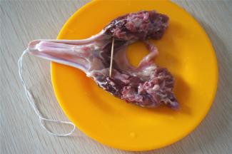 腌制好的腊鸭头，用牙签撑开鸭头（方便晒干），然后在鸭嘴上穿上绳子。