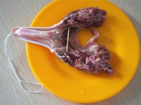 腌制好的腊鸭头，用牙签撑开鸭头（方便晒干），然后在鸭嘴上穿上绳子。