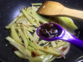 将土豆沥干水分后放入锅中翻炒至变色加入一勺自制豆瓣酱调味