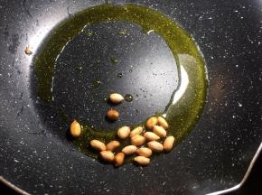 将锅中放油烧热后倒入花生米小火炸8分钟捞出