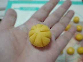 取一份面团稍微压扁，用牙签划出印子，塑造出南瓜造型。