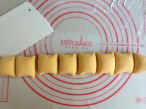 面团取出，在案板上散些面粉，排气，搓成长条，切成8等份