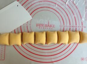 面团取出，在案板上散些面粉，排气，搓成长条，切成8等份