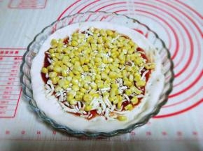 将淋干水分的玉米粒放入披萨底上。再撒上一层马苏里拉芝士。
烤箱2000度预热5分钟，入烤箱中层，200度烤20分钟。根据自家烤箱性能另定哈。