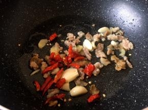 锅里放入生姜大蒜红尖椒爆香 (生姜切片，大蒜拍开，红尖椒切开)