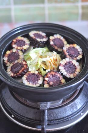 把切段的黑玉米在内胆中铺一圈，加入少许盐、生抽。