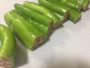 每一根尖椒从中间切成两段，然后塞入肉馅