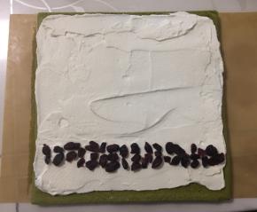 我的夹馅比较薄，喜欢厚夹馅的可以多打发一些奶油。将打发后的奶油用抹刀在蛋糕卷表面抹平整，靠近身体的一侧边缘可以涂抹厚一点，其余三边涂抹的薄一点，然后卷好定型，放入冰箱冷藏。