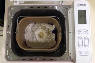 在面包机桶内加入蝶豆花水，细砂糖和盐对角放入，接着倒入全麦面粉和高筋面粉，最后在面粉上挖个洞，加入酵母粉（除黄油以外的材料，按照先液体后粉类的顺序），启动面包机和面程序10分钟。