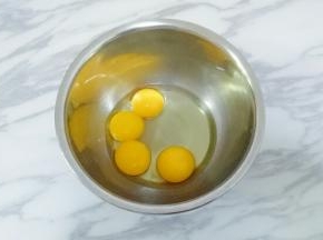 将1个全蛋和三个蛋黄打入打蛋盆中