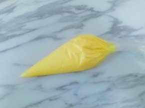 将翻拌好的饼干糊装入裱花袋中，用剪刀将裱花袋剪个圆口